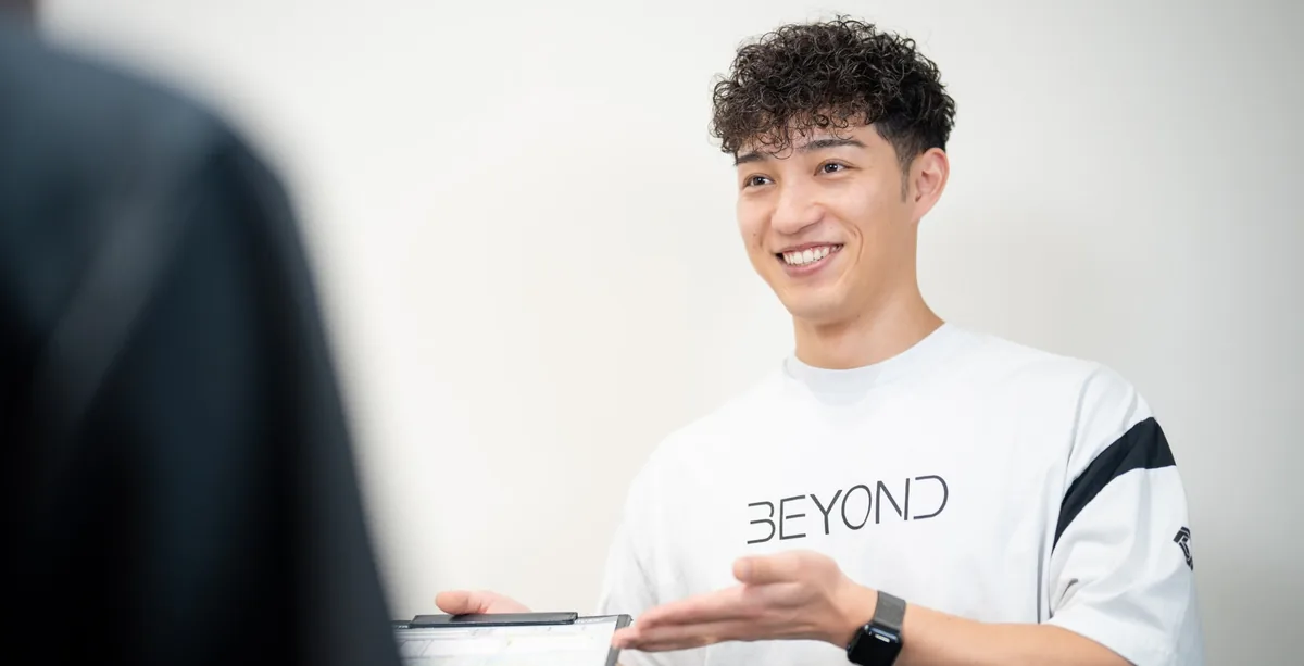 笑顔で料金や流れを説明するBEYONDのトレーナー